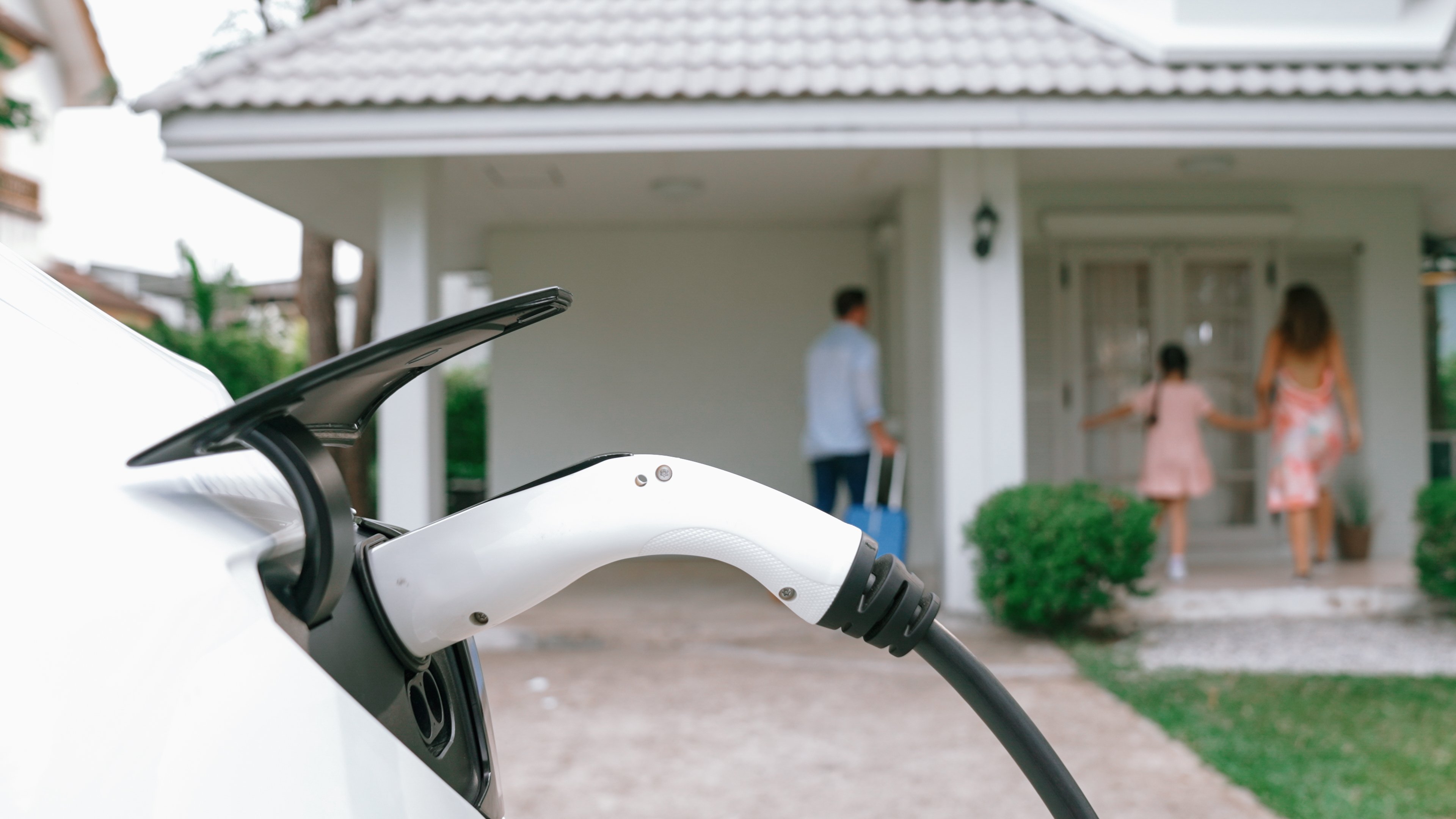 Happy family return from holiday and travel using EV car