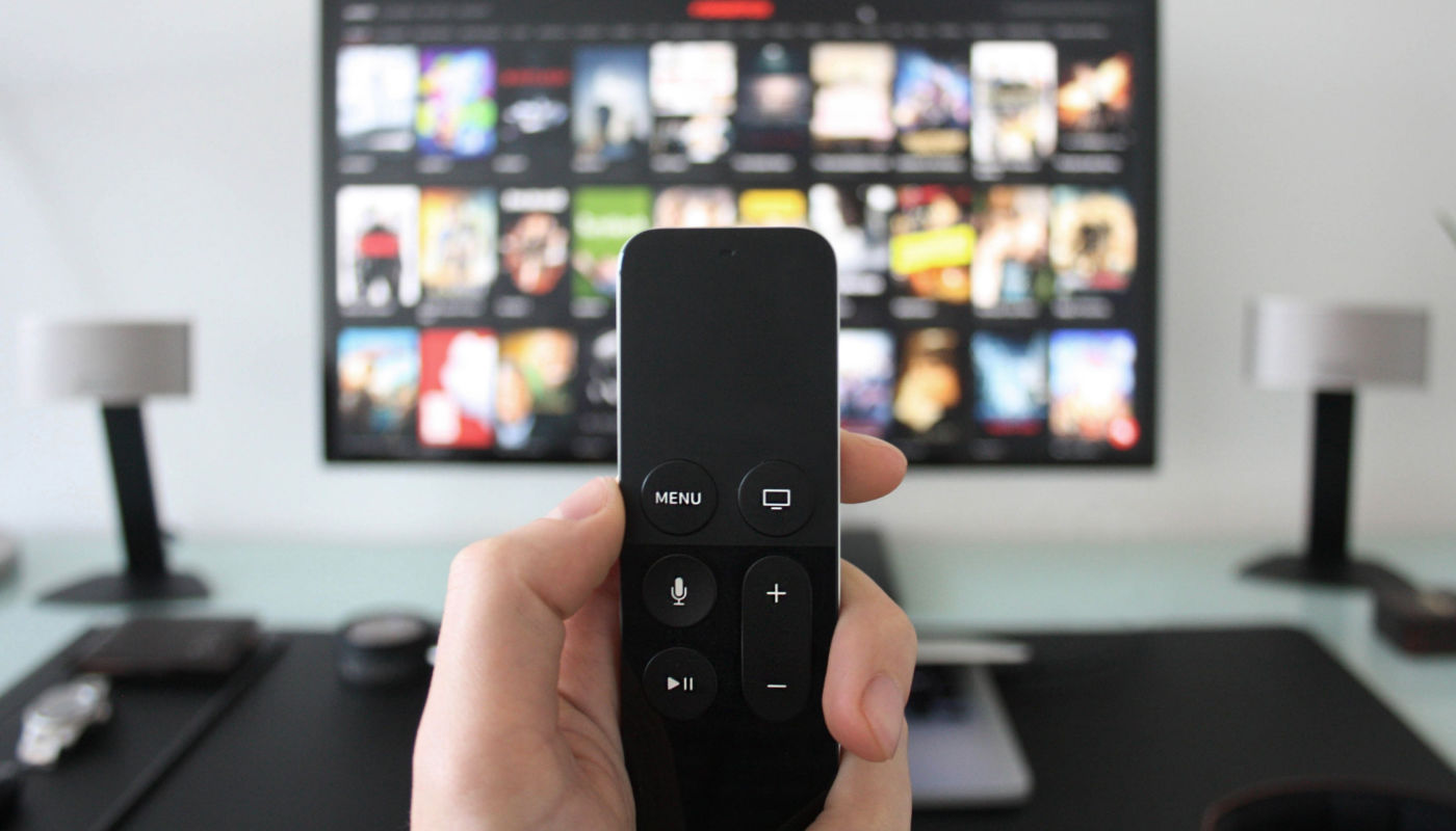 holding remote in front of tv streaming service