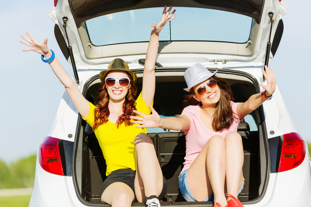 two friends relaxing in the back of a car on a summer day