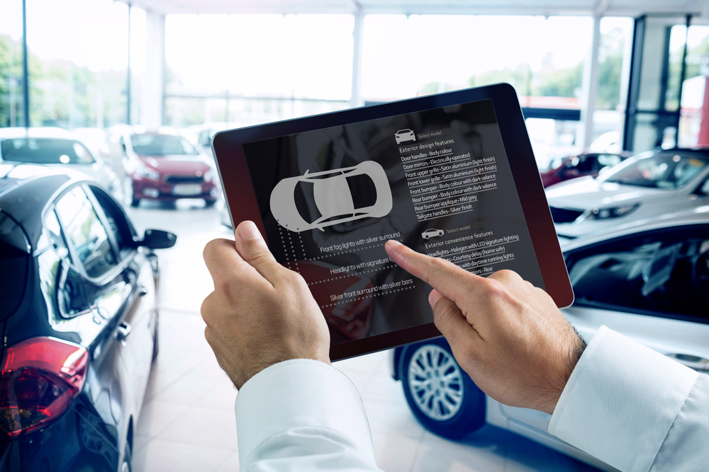 man using tablet at car dealership