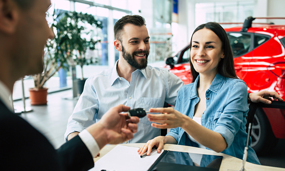 Dealer Handing Keys To New Customer After Winning A Deal