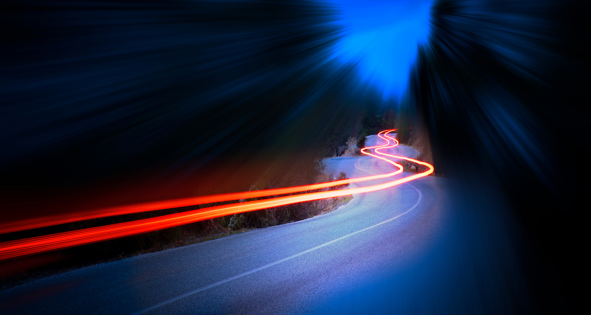 car speeding through highway with trailing lights