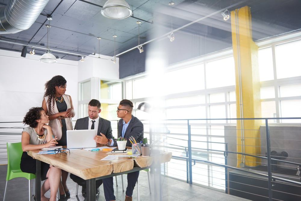 four employees meeting at a table